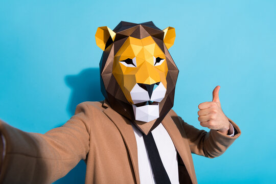 Portrait of weird authentic guy in lion mask make selfie enjoy crazy festival show thumbup symbol isolated over blue color background
