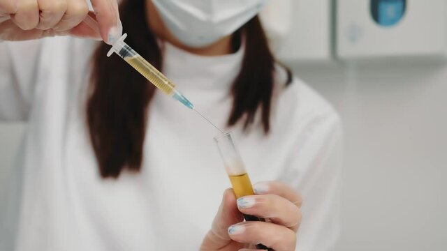 the doctor draws blood plasma into the syringe for further injection to the patient.