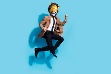 Full length photo of freak absurd guy in lion mask character jump raise fists win theme event...