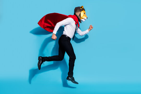 Full length profile side photo of weird guy lion mask wear red mantle jump up run hurry save world isolated over blue color background