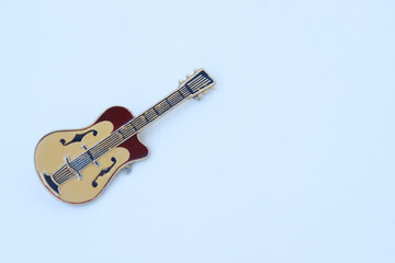 Brooch in the form of a guitar on a white background