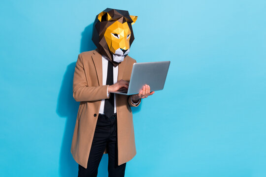 Photo of focused manager guy in lion mask typing netbook app search report isolated over blue color background
