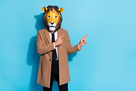 Photo of weird crazy guy lion mask point finger empty space demonstrate mardi gras ads isolated over blue color background