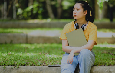 A teenage woman holding a tablet with a worried expression.