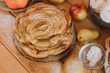 apple pie charlotte closeup. homemade cakes, sweets and fruits are on the wooden kitchen table. High quality photo