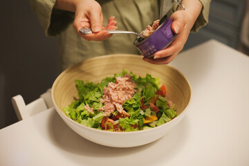 person preparing a bowl of tuna salad