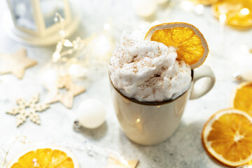 A cup of cocoa or hot chocolate with whipped cream on a Christmas or New Year light background