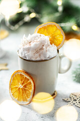 A cup of cocoa or hot chocolate with whipped cream on a Christmas or New Year light background