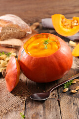 bowl of pumpkin soup on wooden board