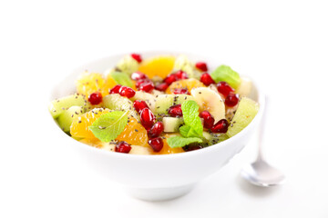 fresh fruit salad in bowl isolated on white background (orange,  pomegranate,  kiwi and banana)