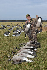 Naklejka premium Hunter with a trio of geese 