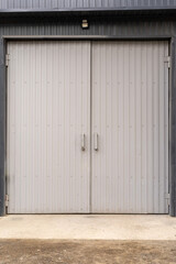 Vertical photo of a gray metal gate. Entrance to the garage for car