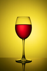 a glass of red wine on a yellow background