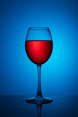 a glass of red wine on a blue background