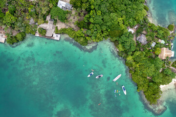 beautiful shot of boats anchored along the coast of an island during the summer