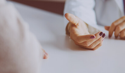 Woman doctor helping senior holding hand in hospital