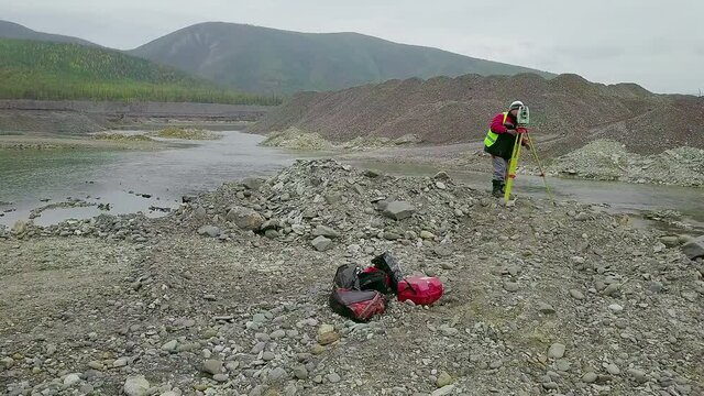 Professional Surveyor Searching Gold Metal Ore Operates Geological Tacheometer Equipment. Worker Searches Gold Material Using Industrial Geological Equipment. Gold Searching Tacheometer Equipment 