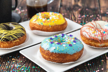 Delicious donuts decorated with different decorations on wooden table