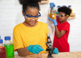 Cute afro hair girl and boy kid study science with microscope and test chemical
