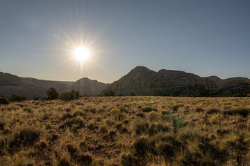 Sun Burst Over Field of Grass and Geological Features
