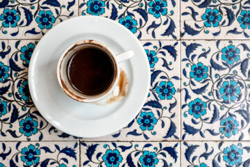 Leftover coffee, sediment, precipitate black turkish coffee in ceramic white cup, top view