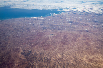 Aerial view from airplane during international flight. Travel in airplane, landscape from above and clouds.