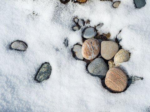 small stones on snow-covered ground