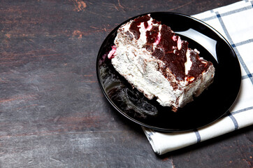 Plate with slice of tasty chocolate cake on table. Yummy dessert on on wooden background, closeup