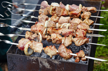 Marinated shashlik preparing on a barbecue grill over charcoal. Traditional Russian shashlik on a barbecue skewer
