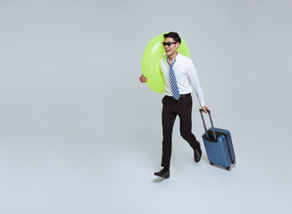 Happy smiling Asian businessman with suitcase and rubber ring enjoying their summer vacation...
