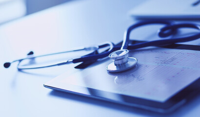 Medical equipment: blue stethoscope and tablet on white background. Medical equipment