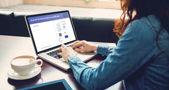 Caucasian woman using laptop with covid vaccination certificate and qr code on screen