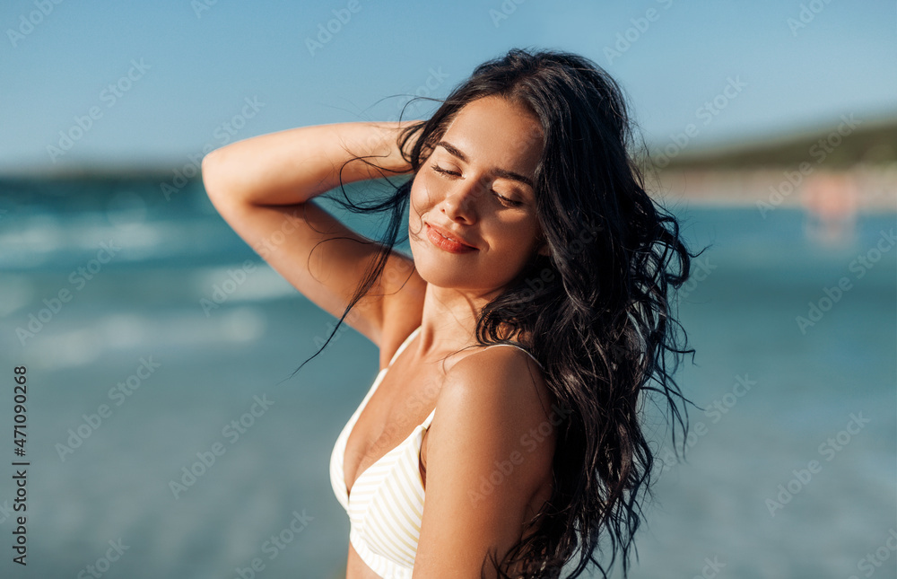 Wall mural people, summer and swimwear concept - happy smiling young woman in bikini swimsuit on beach