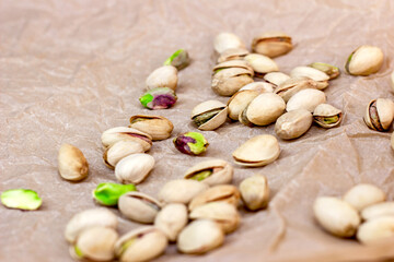Roasted salted pistachio nuts in nutshell on light background.