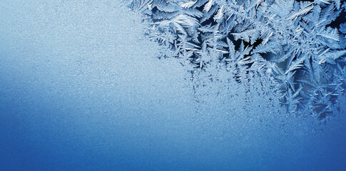 Winter frosty blue patterns on the glass. Icy, frosty pattern on the window glass. Background for...