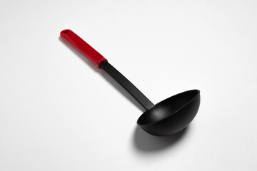 Black plastic soup ladle isolated on white background. The big black serving spoon.High-resolution...