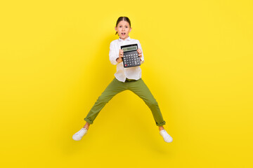 Fototapeta na wymiar Full length body size view of attractive worried girl jumping showing budget calculator isolated over bright yellow color background