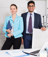 Successful young business team standing at workplace in office