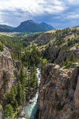 Sunlight Creek flows through the Sunlight Gorge on the Chief Joseph Highway just outside the Beartooth and Yellowstone National Park in Wyoming on a sunny summer afternoon - mountains and storm