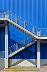 stairs made of steel in front of blue metal wall