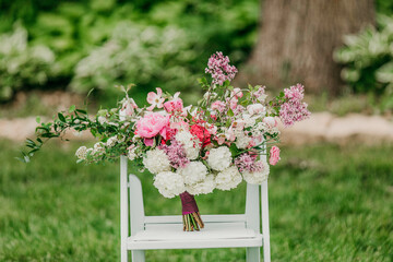 Wedding bouquet of flowers in a vase on a reception table for bride and groom 
