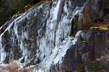 Fototapeta na wymiar Rock wall covered in icicles in the Jacques-Cartier National Park valley seen during late Fall, Stoneham-et-Tewkesbury, Quebec, Canada