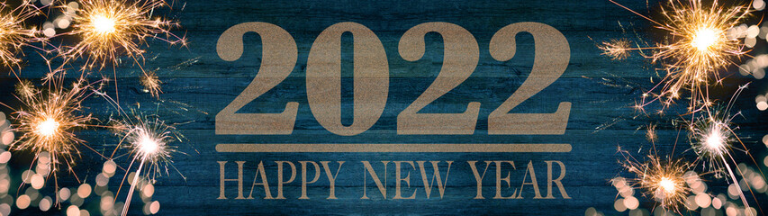 HAPPY NEW YEAR 2022, golden bokeh flares and sparkler isolated on rustic blue wooden texture -...
