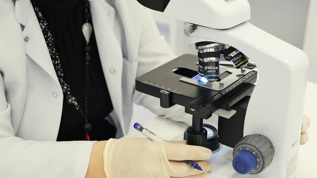 Doctor working with a microscope closeup. Electron microscope in action.