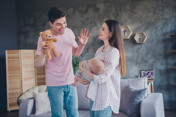 Portrait of attractive cheerful married spouses rocking cute infant having fun good mood enjoying...