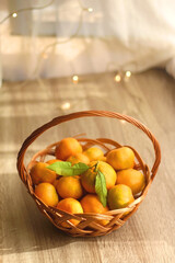 Vintage basket filled with fresh tangerines. Bokeh lights in the background. Selective focus.