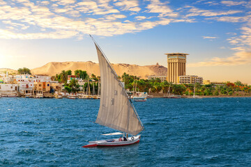 Felucca in the blue waters of Nile, Aswan city, Egypt