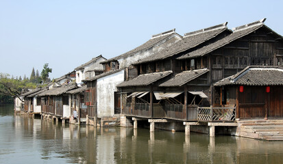 Fototapeta na wymiar Wuzhen Water Town, Zhejiang Province, China. Traditional wooden houses beside a canal in the old Chinese town of Wuzhen. Wuzhen Canal Town is also known as the Venice of the East.