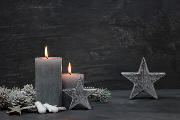 Weihnachtshintergrund: Kerzen mit Weihnachtsschmuck vor einem dunklen Hintergrund.