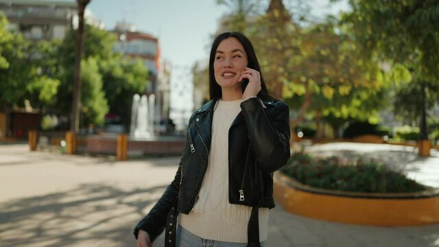 Young hispanic woman smiling confident talking on the smartphone at park